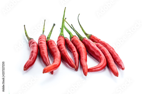 mini pods of red chili peppers hot additive to meat and chicken giving flavor to a group of vegetables on a white background