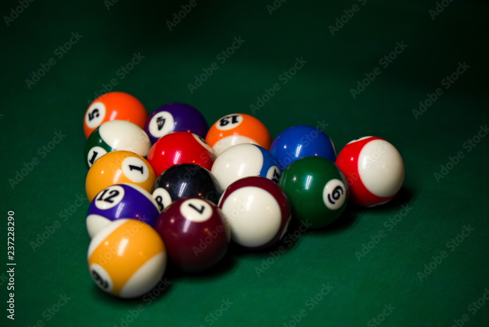 Sport billiard balls set arranged in shape of triangle on green billiard table in pub. Players are ready for the first hit of the round to start the billiard game. Sport billiard balls set arranged in shape of triangle on green billiard table in pub. Players are ready for the first hit of the round to start the billiard game.