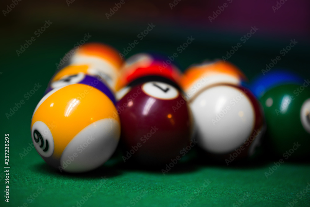 Sport billiard balls set arranged in shape of triangle on green billiard table in pub. Players are ready for the first hit of the round to start the billiard game. Sport billiard balls set arranged in shape of triangle on green billiard table in pub. Players are ready for the first hit of the round to start the billiard game.