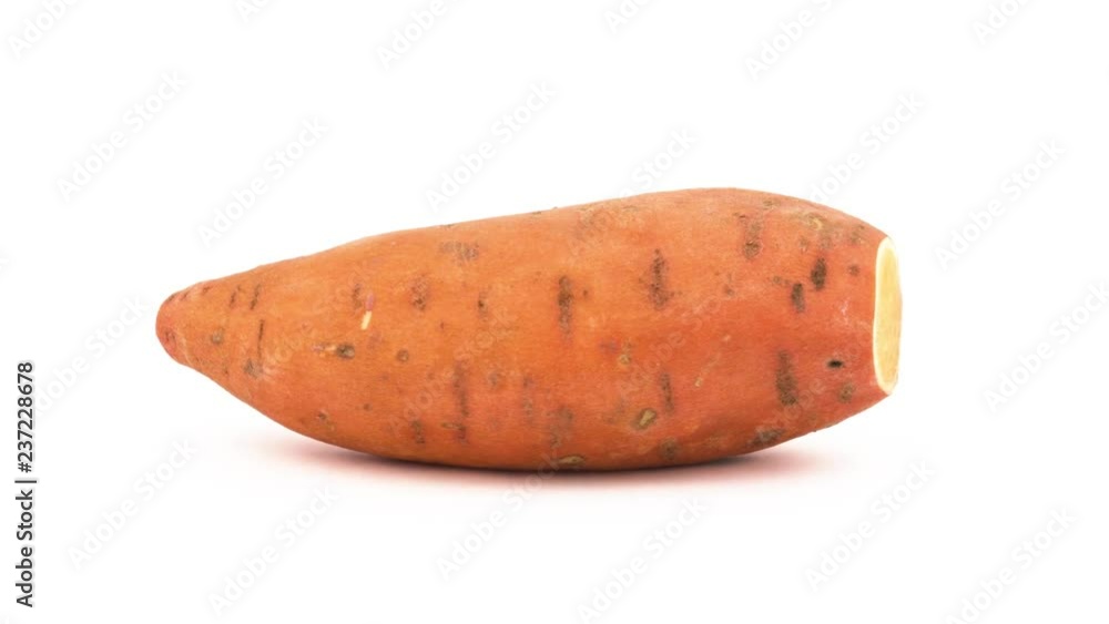 One whole sweet potato and few batata slices rotating on the turntable. Isolated on the white background. Close-up. Macro. One whole sweet potato and few batata slices rotating on the turntable. Isolated on the white background. Close-up. Macro.
