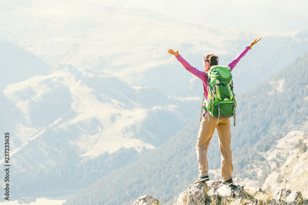 Happy woman walking with backpack in Pyrenees mountains Highlands