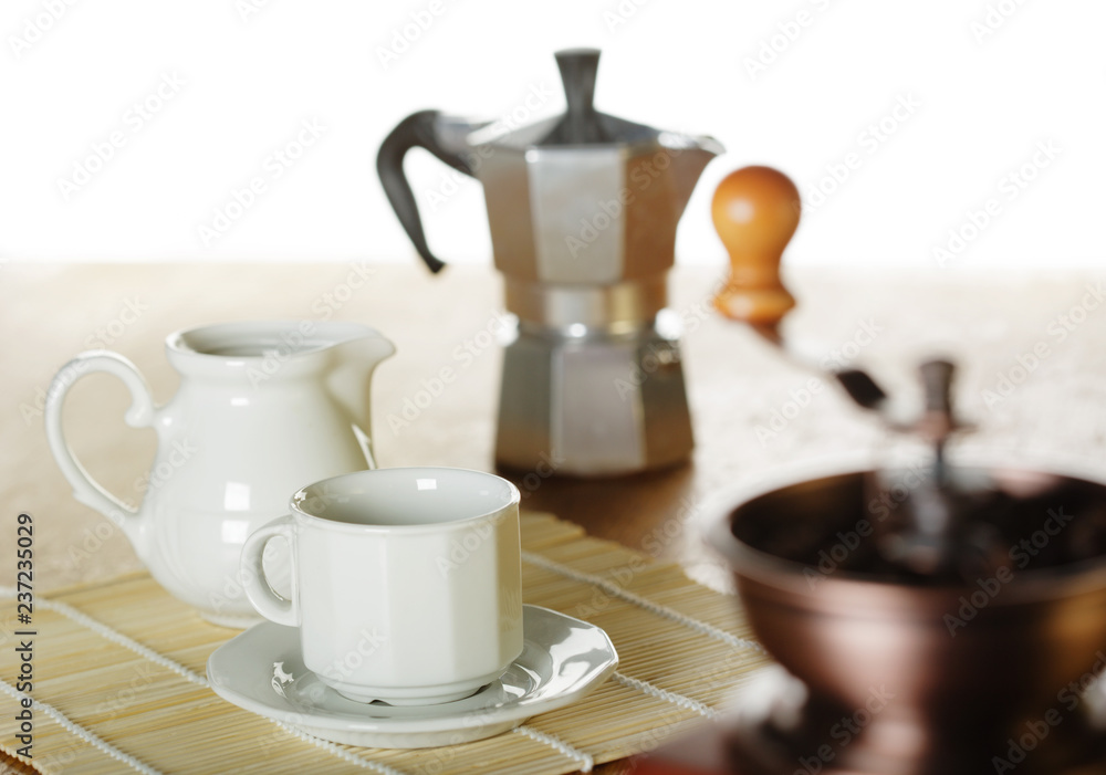 Making coffee. Coffee grinder, cup, light background Making coffee. Coffee grinder, cup, light background