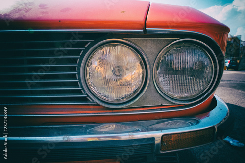 Close-up of headlight of a red vintage classic car.