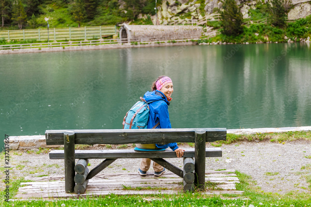 Woman sitting on a bench and enjoying the view at the beautiful alpine lake in Nuria valley, Spain Pyrenees Woman sitting on a bench and enjoying the view at the beautiful alpine lake in Nuria valley, Spain Pyrenees