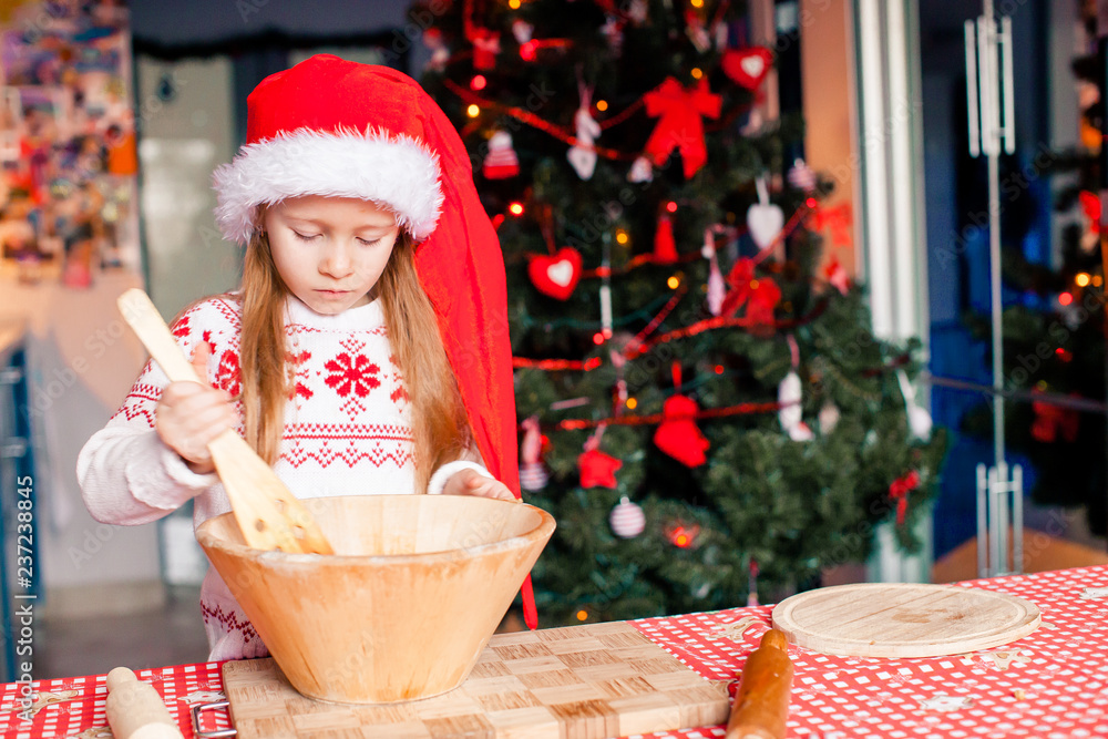 Adorable little girl baking Christmas gingerbread cookies Adorable little girl baking Christmas gingerbread cookies