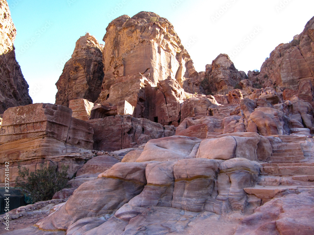 Dwellings of ancient people in red stone rocks in the canyon in Jordan
