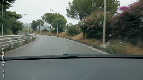 Driving out of Taormina to get on highway. Sicily, Italy. Signs for Catania and Messina. Some smudges on windshield. photo
