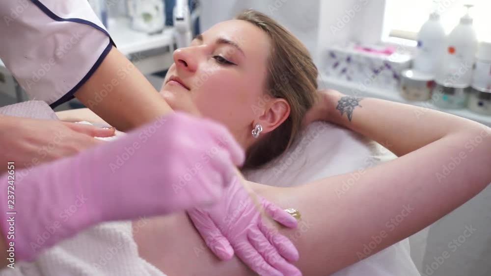 The girl at the reception at the beautician. The girl makes depilation. Removal of unnecessary hairs. The girl shaves her hair under her arms. The girl at the reception at the beautician. The girl makes depilation. Removal of unnecessary hairs. The girl shaves her hair under her arms.