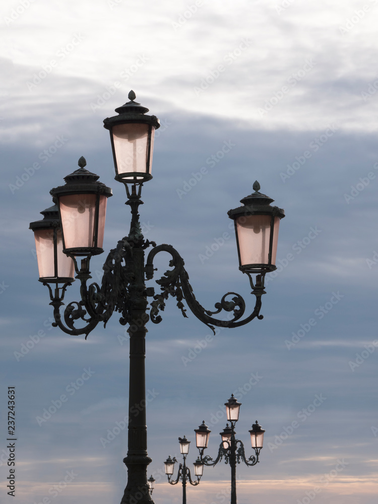 Street light lanterns or lamps against the blue sky. Scenic view of vintage lanterns isolated on sky background. No people.