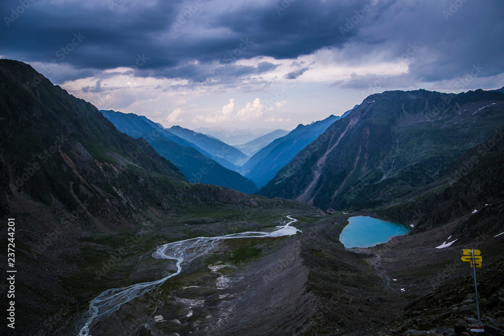 Valley in the Alps (Austria, Europe). Beautiful nature, high mountains, summer day, snowy peaks. Hike in the rocks, traveling with a backpack.