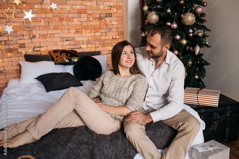 Merry Christmas and Happy Holidays! Couple on Christmas at home on bed near