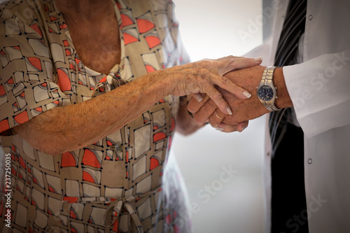 Midsection of a doctor holding an old womanâ€™s hand. photo