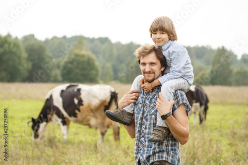 Portrait of a father and son on the background of nature. Dad and child in a field at sunset.