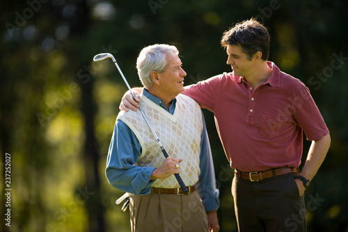 Man with his arm around father on golf course photo