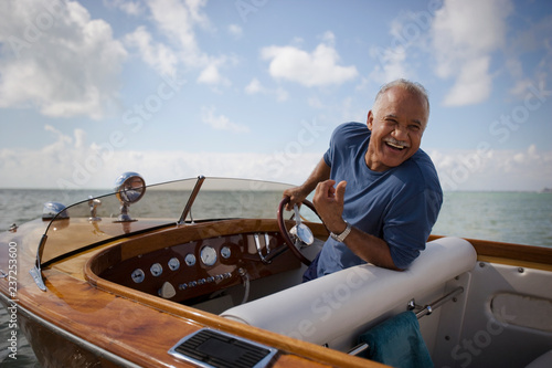 Smiling mature man sitting in his boat.