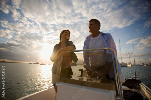 Happy mid-adult couple on a boat together on the ocean. photo
