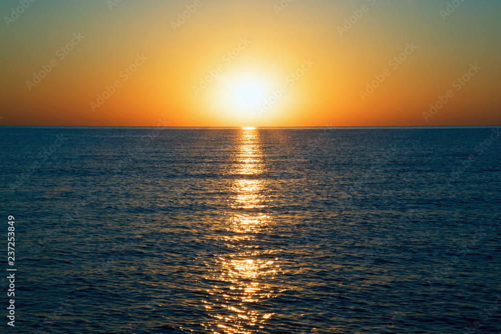 Sunrise on the black sea with glare on the water.