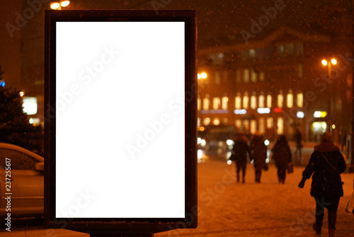 city outdoor billboard mockup winter city with snow going. Glows in the darkness of the night city.