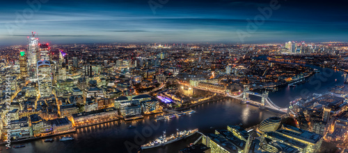Weites Panorama der hell beleuchteten Skyline von London entlang der Themse am Abend, Großbritannien