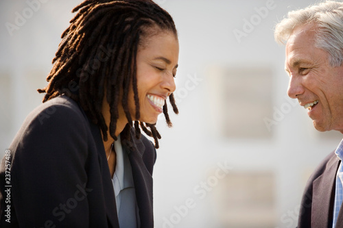 Mid-adult businessman speaking with a male colleague outside. photo