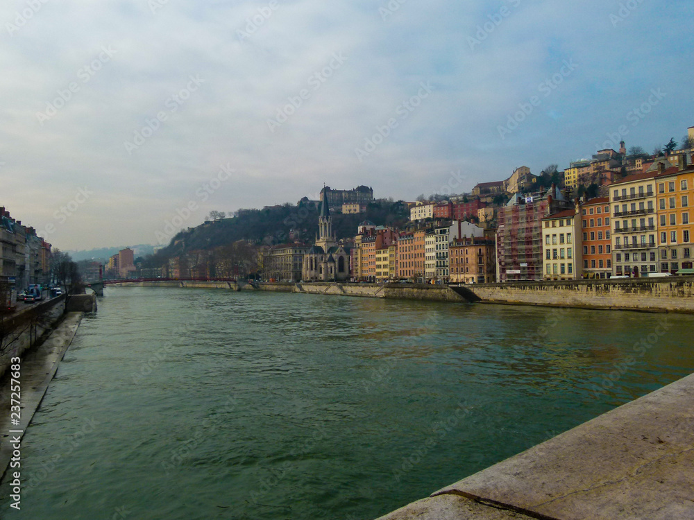 Beautiful view of the river and the vintage colorful buildings on the shore in winter Lyon, France