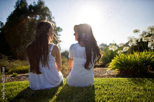 Two teenage girls sitting in the garden. photo