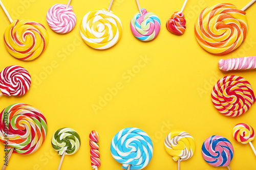 Colorful lollipops on yellow background