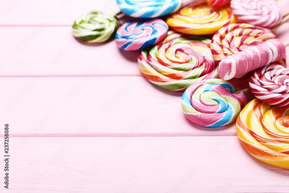 Colorful lollipops on pink wooden table Colorful lollipops on pink wooden table