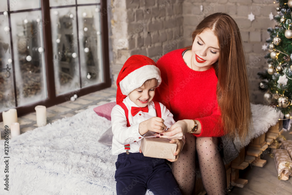 Fototapeta premium Happy funny family near the Christmas tree unpacks gifts. New Year's Concert