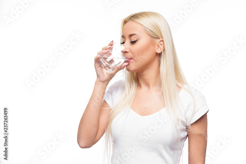 Healthy blond woman holding and drink glass of water on isolated white background