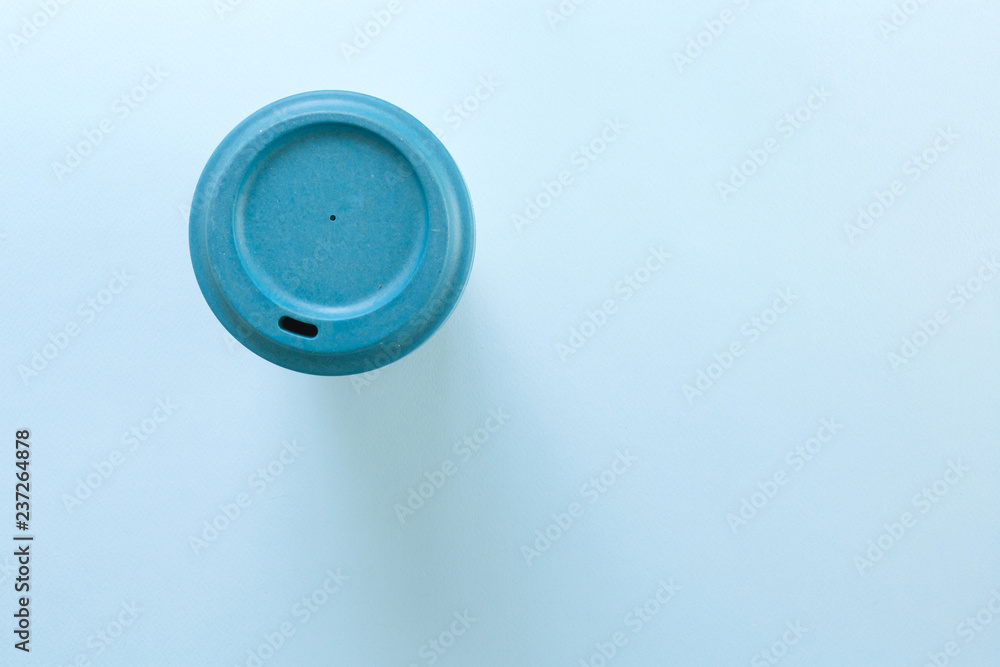 Bamboo reusable takeaway cup with lid on, flat lay on blue background. Bamboo reusable takeaway cup with lid on, flat lay on blue background.