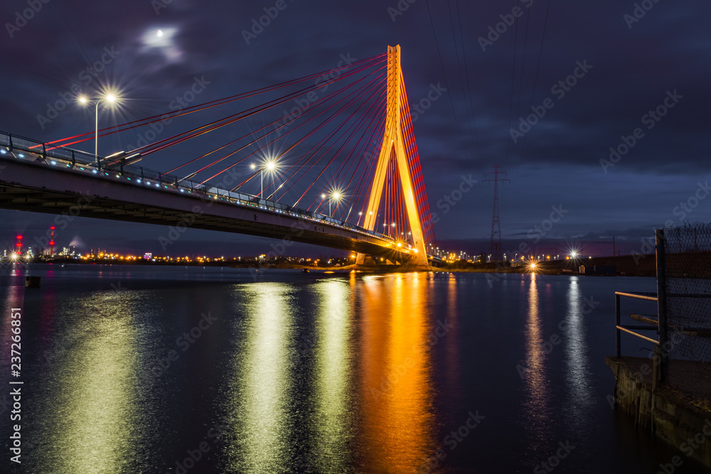 Illuminated cable stayed bridge over Martwa Wisla river at night in Gdansk. Poland Europe
