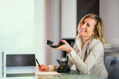 Happy fashion designer talking phone in office photo