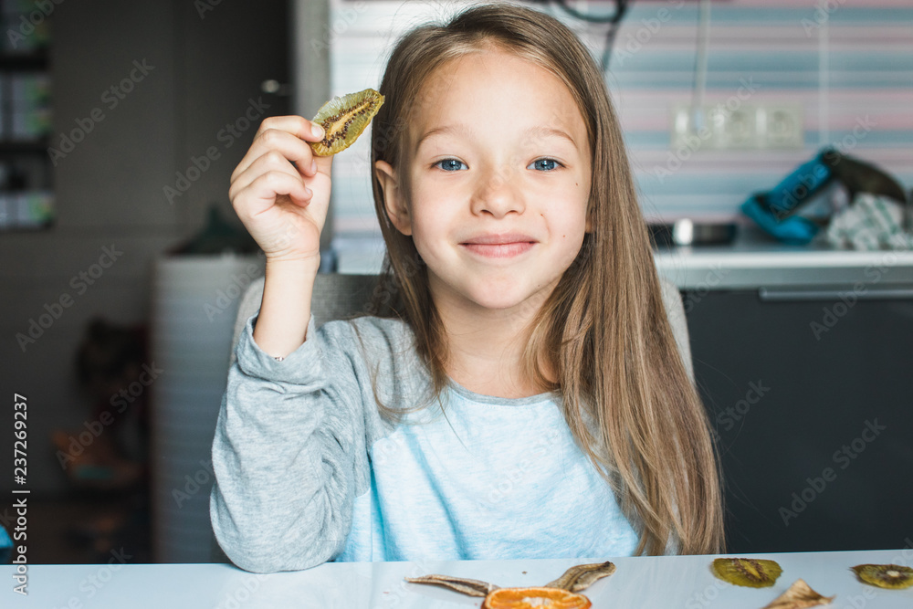 Cheeky cute blond little girl playing with dried fruit Cheeky cute blond little girl playing with dried fruit