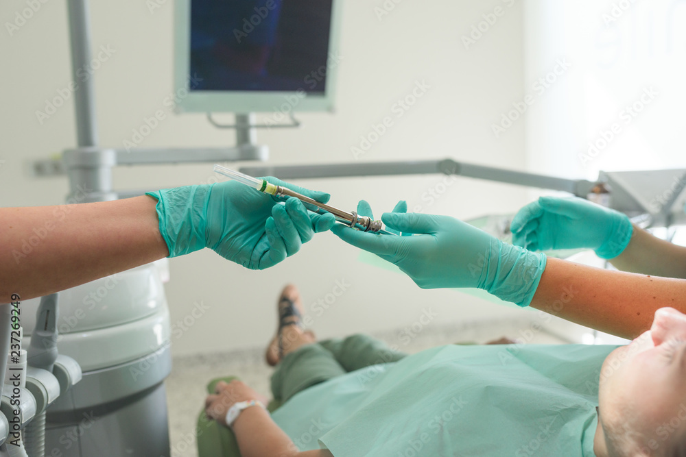 Nurse giving the anesthesia injection to orthodontist Nurse giving the anesthesia injection to orthodontist