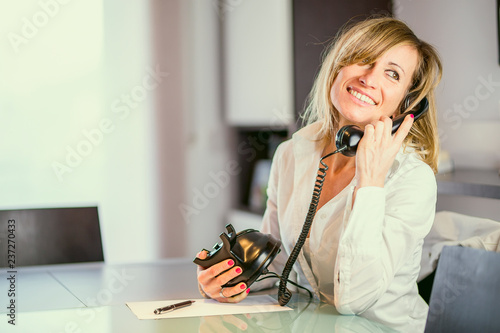 Happy fashion designer talking phone in office photo