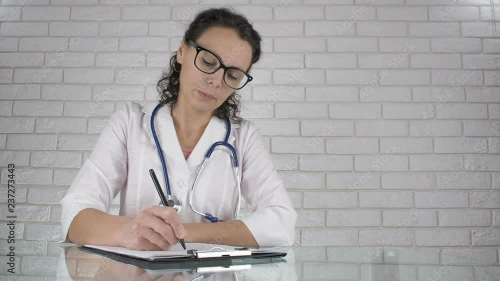 Woman doctor in the office. The female doctor fills out the medical records. Woman doctor in the office. The female doctor fills out the medical records.
