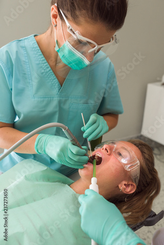 Portrait of female orthodontist treating patient in dental office photo