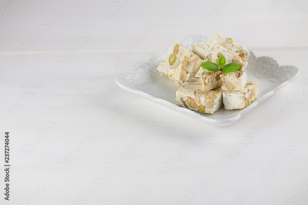 Italian torrone or nougat with almonds and pistachios from Apulia, traditional christmas sweets. Copy space Italian torrone or nougat with almonds and pistachios from Apulia, traditional christmas sweets. Copy space
