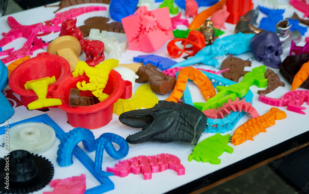 Fototapeta premium Models printed by 3d printer. Bright colorful objects printed on a 3d printer on a table close-up. Fused deposition modeling, FDM. Concept modern progressive additive technology for 3d printing.