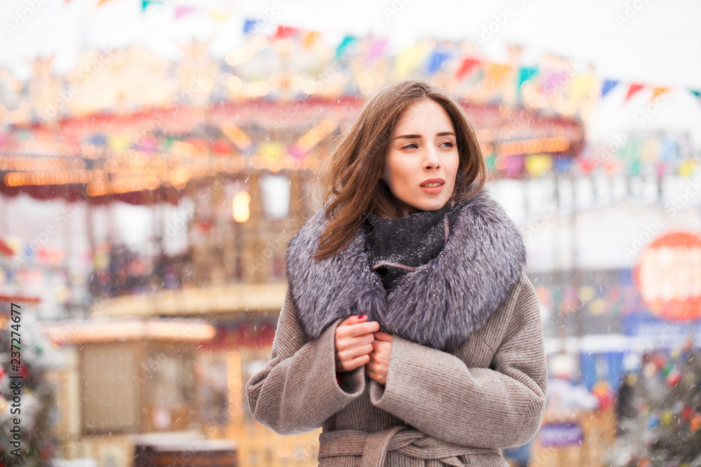 Young brunette woman in a gray coat with a fur collar Young brunette woman in a gray coat with a fur collar