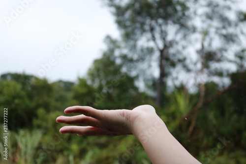 hand reaching out for raindrops