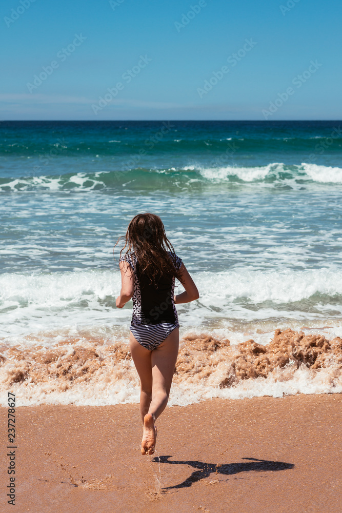 teens at the beach, running into the ocean teens at the beach, running into the ocean