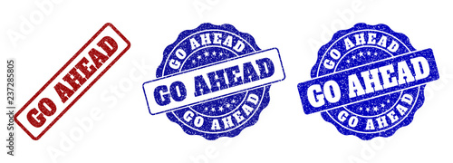 GO AHEAD grunge stamp seals in red and blue colors. Vector GO AHEAD watermarks with grunge texture. Graphic elements are rounded rectangles, rosettes, circles and text titles.