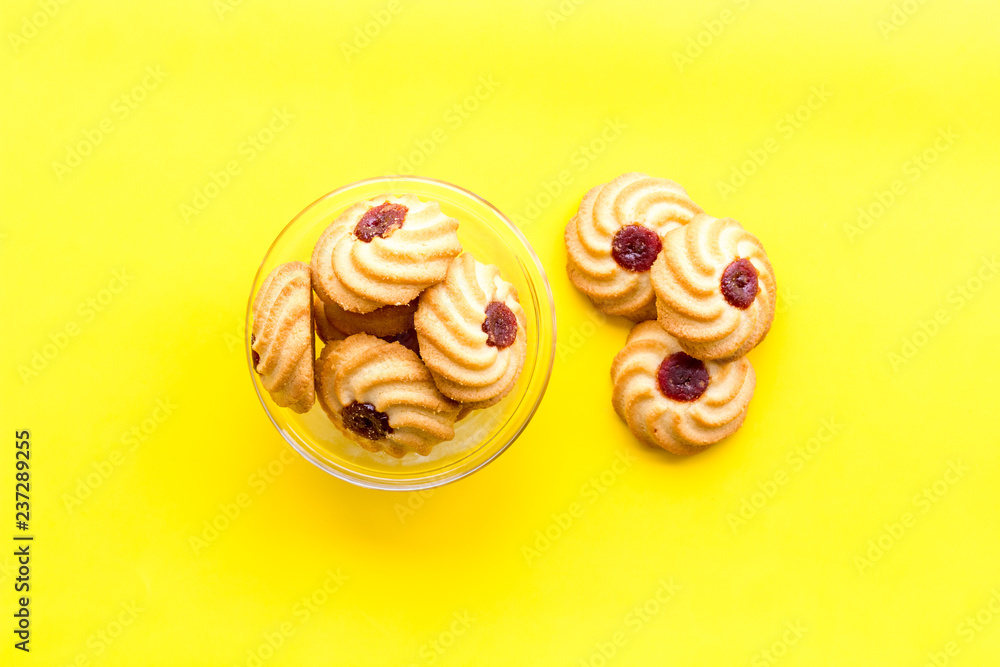 Homemade cookies. Kurabe in glass bowl on yellow background top view copy space