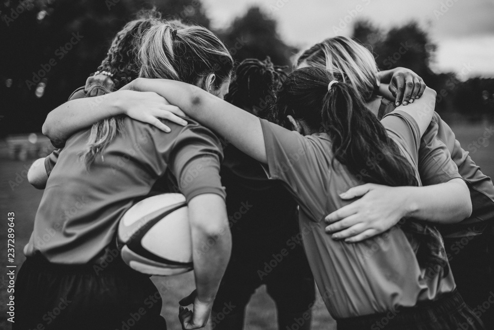 Young female rugby players huddling