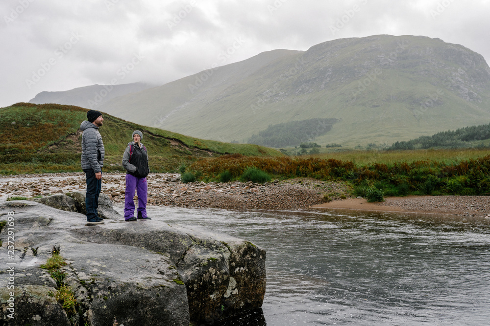 Couple by the river in Glen Etive, Scotland