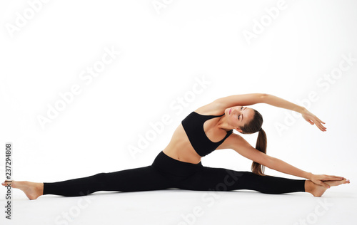 Young woman practicing yoga, working out, wearing sportswear, st