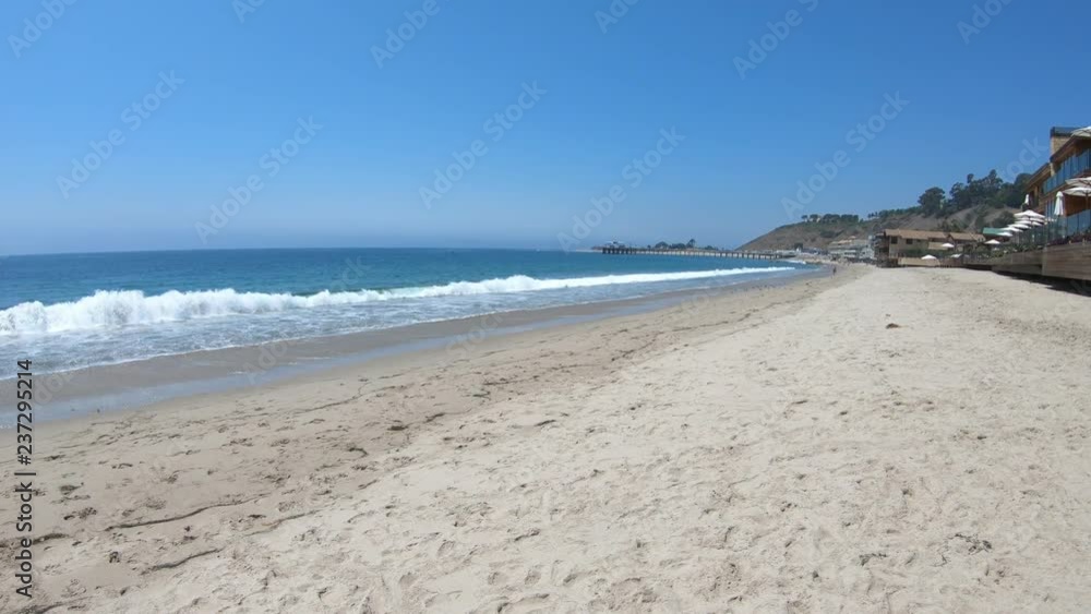 Carbon Beach or Billionaire Beach of Malibu. Malibu Pier on background. California West Coast landscape. Blue sky, copy space. Summer season. Carbon Beach or Billionaire Beach of Malibu. Malibu Pier on background. California West Coast landscape. Blue sky, copy space. Summer season.