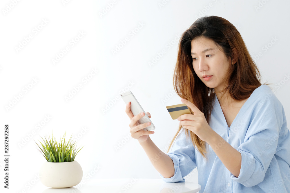 Young asian woman holding credit card and using smart phone for shopping online, business and technology concept, online payment, digital money Young asian woman holding credit card and using smart phone for shopping online, business and technology concept, online payment, digital money